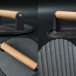 Pode incluir: Uma prensa para hamb&uacute;rgueres em ferro fundido com cabo de madeira. A prensa tem uma base redonda com uma superf&iacute;cie canelada para criar marcas de grelha. A pega &eacute; fixada &agrave; base com um suporte met&aacute;lico.