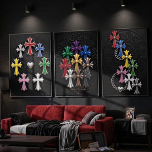 May include: A set of three black framed wall art pieces featuring embossed Chrome Hearts branding. The artwork displays various colourful cross motifs in red, blue, green, yellow, pink, white, and metallic tones arranged in circular and cluster patterns.