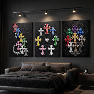 May include: A set of three rectangular wall art canvases featuring embossed black backgrounds with the text CHROME HEARTS. Each canvas displays a collection of multi-coloured, three-dimensional cross emblems in red, blue, yellow, green, pink, white, and silver.
