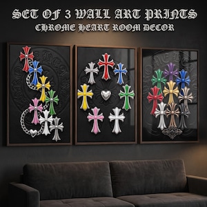 May include: A set of three wall art prints titled SET OF 3 WALL ART PRINTS CHROME HEART ROOM DECOR. Each print features a black background with embossed circular patterns and various colourful cross-shaped emblems in red, blue, yellow, green, pink, and silver.