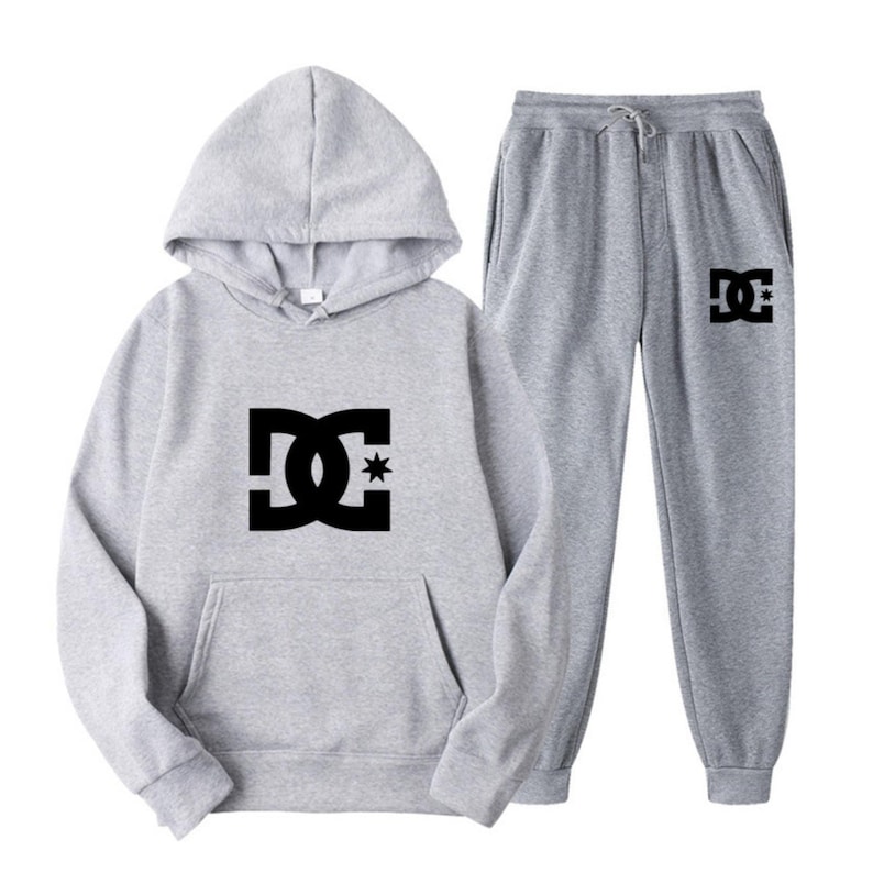 Peut inclure: Ensemble sweat-shirt et pantalon de surv&ecirc;tement gris. Le sweat-shirt &agrave; capuche a un cordon de serrage et une poche kangourou. Les deux pi&egrave;ces pr&eacute;sentent un logo noir avec une &eacute;toile. Le pantalon a une taille &eacute;lastique.