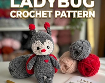 May include: A crocheted ladybug amigurumi with a red heart on its chest, red wings, and antennae. The image includes gray, pink, and red yarn balls, a crochet hook, and a pattern book with the text "Ladybug Crochet Pattern."