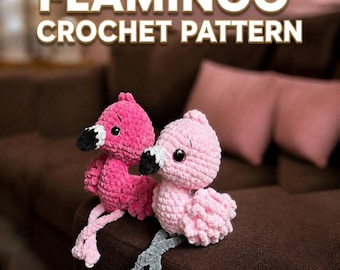 May include: Two plush flamingo toys made of soft yarn, one in bright pink and one in light pink. Both have black and white beaks, dark eyes, and long dangling legs. The text FLAMINGO CROCHET PATTERN is displayed in white letters at the top of the image.