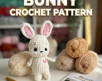 May include: A white crochet bunny with pink inner ears and a pink heart. The image includes the text "BUNNY CROCHET PATTERN" and several balls of yarn in beige and brown tones, along with a crochet hook and a pattern booklet.