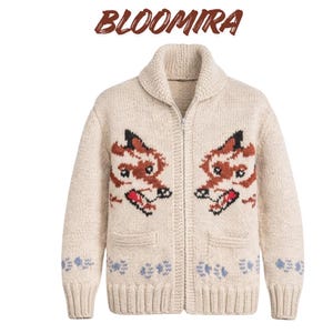 May include: Cream-coloured zip-up cardigan sweater with two fox face designs. The sweater has a shawl collar, two front pockets, and blue floral accents at the bottom. The word "BLOOMIRA" is written in brown script at the top.