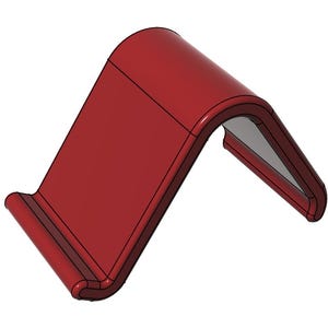 May include: A red, angled phone stand with a curved top and a lip at the base to hold a phone. The stand is made of a solid material and has a smooth finish. The design is simple and modern.