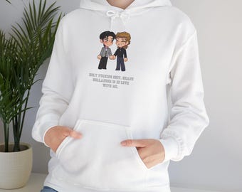 May include: White hoodie with a front pocket and a drawstring hood. The hoodie features a cartoon illustration of two people holding hands, with the text "HOLY FUCKING SHIT, BEANIE BELLAHER IS IN LOVE WITH ME."