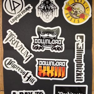 May include: A selection of white-bordered stickers with band logos and names. Includes logos for Linkin Park, Guns N' Roses, Trivium, Cypress Hill, and Architects. Other stickers feature the text "BAD OMENS", "DOWNLOAD", "A DAY TO REMEMBER", and "limpbizkit".