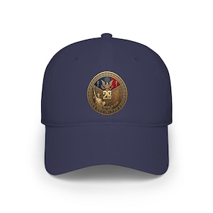Peut inclure: Casquette de baseball bleu marine avec un écusson doré. L'écusson affiche le texte "26 WORLD CUP USA 2026", la Statue de la Liberté et un aigle. Un accessoire de mode pour les fans de sport.
