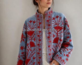 May include: A light blue jacket featuring vibrant red floral embroidery throughout the front panels and sleeves. The garment has a high collar, long sleeves, and an open front design. The text ASSUHANDICRAFTINDIA is visible across the center.