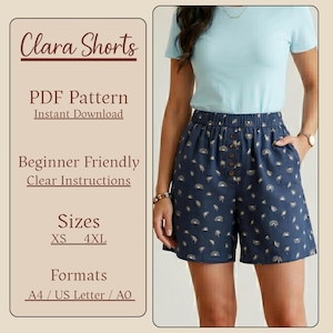 May include: Navy blue shorts with a repeating sunburst pattern and wooden buttons. The shorts have an elastic waistband and pockets. The image also includes text that reads "Clara Shorts", "PDF Pattern", "Beginner Friendly", and "Sizes XS - 4XL".