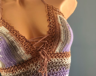 May include: A crocheted halter top with a brown, beige, and purple striped pattern. The top has a lace-up detail in the front.