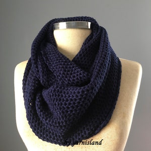 May include: A navy blue knitted infinity scarf. The scarf is made of a soft, chunky yarn and is perfect for keeping warm in the winter.