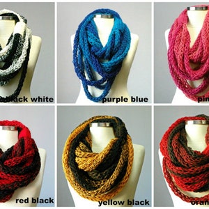 May include: Six infinity scarves in different color combinations. The scarves are made of a chunky yarn and are shown on a mannequin. The colors are black and white, purple and blue, pink shades, red and black, yellow and black, and orange and brown.