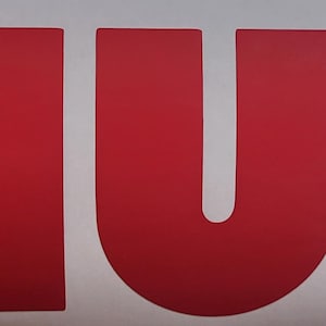 May include: A white sticker with the word "THULE" in large, bold, red letters. Below the word "THULE" is the word "SWEDEN" in smaller, black letters.