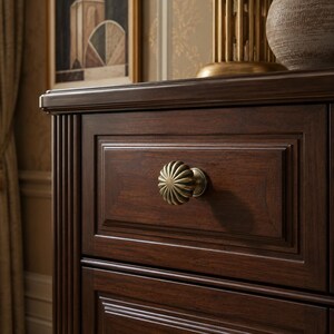 May include: A dark brown wooden drawer featuring a round, fluted brass knob with a metallic finish. The drawer front has a recessed rectangular panel design with beveled edges, showcasing a smooth wood grain texture and a polished, deep finish.