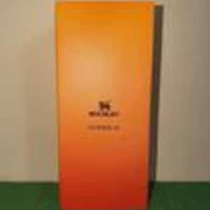 May include: A rectangular box with a vertical gradient transitioning from yellow at the top to orange at the bottom. The center features a black logo of a stylized animal silhouette above the text WAKAY and the word ESSENTIALS in black.
