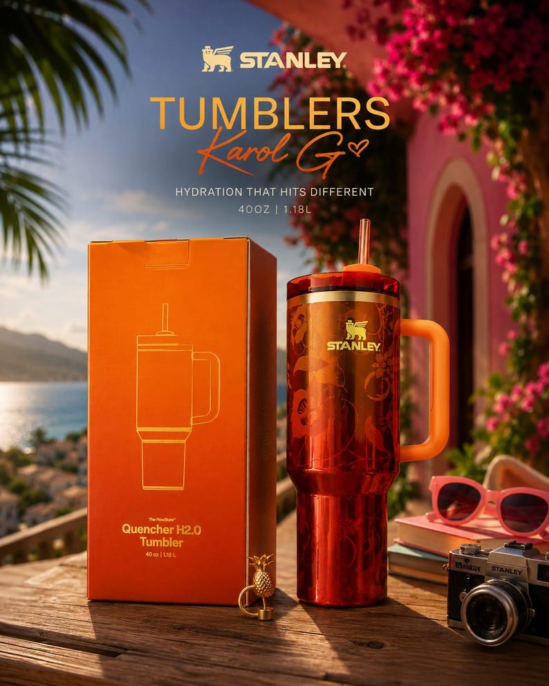 May include: A 40 oz Stanley Quencher H2.0 tumbler in a deep red finish with a floral pattern, featuring a matching orange handle, a red lid, and an orange straw. The tumbler is displayed next to its orange box labeled 40 oz | 1.18L.