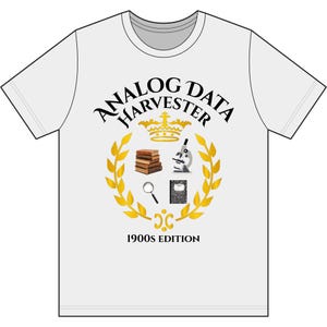 May include: A white short-sleeve t-shirt featuring a graphic with the text ANALOG DATA HARVESTER and 1900S EDITION. The design includes a gold crown, a stack of brown books, a microscope, a magnifying glass, and a notebook inside a gold laurel wreath.