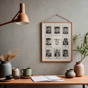 May include: A framed print displaying nine black and white tarot-style cards with graduation photos. The text "Different cards, Same deck" is centered on the print. The print is suspended on a grey wall above a wooden table with vases, mugs, and an open book.