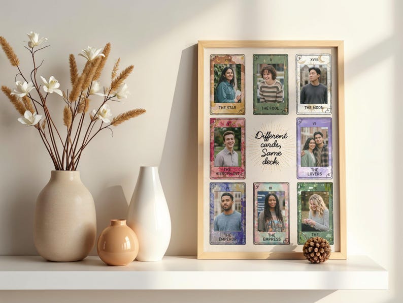 May include: A framed print displaying tarot cards with portraits. The cards are labelled with titles such as "The Star," "The Fool," and "The Moon." The text "Different cards, Same deck" is also visible. Decorative vases and a pinecone are on a white shelf.