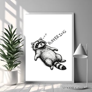 May include: A framed white wall art print featuring a black and white ink illustration of a raccoon lying on its back with its eyes closed, sleeping with the text "BUFFERING" and "zzz" written in black ink above the animal's head.