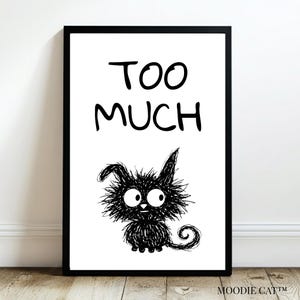Pode incluir: Impressão de arte emoldurada em preto com as palavras "TOO MUCH" acima de uma ilustração de gato preto extravagante. O gato tem olhos grandes e uma aparência fofa e espinhosa. A impressão está em um fundo branco.