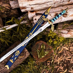 K&ouml;nnte beinhalten: Ein silbernes und goldenes Fantasy-Schwert mit einer blauen und goldenen Scheide. Das Schwert hat einen detaillierten Knauf und eine Klinge. Die Scheide ist mit goldenen Akzenten und Symbolen verziert. Das Schwert und die Scheide liegen auf Holzst&auml;mmen und Gr&uuml;n.