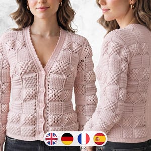 May include: A light pink long-sleeve cardigan featuring a V-neckline, a front button closure, and a textured crochet pattern composed of alternating square blocks of raised bobble stitches and horizontal ribbed lines throughout the garment.