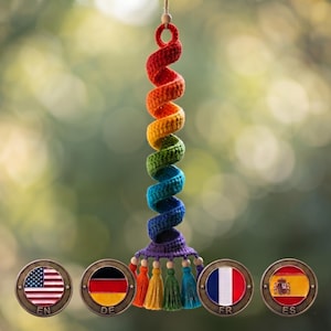 Può includere: Una decorazione all'uncinetto da appendere con un design a spirale in un gradiente di colori arcobaleno rosso, arancione, giallo, verde, blu e viola. La base della spirale include quattro nappe pendenti abbinate e piccole perline di legno.