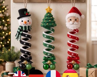 May include: Three hanging crochet Christmas decorations featuring a snowman in a black top hat, a green Christmas tree with a yellow star, and a Santa Claus head. Each ornament has a spiral body, a satin bow, and two hanging bauble ornaments.