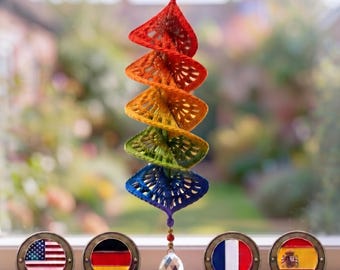 May include: A hanging spiral decoration made of crocheted triangular segments in a rainbow gradient of red, orange, yellow, green, and blue. A clear faceted crystal bead hangs from the bottom, and small colorful beads top the structure.