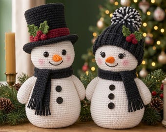 May include: Two crocheted snowmen figures with white bodies and black scarves. One wears a black top hat with red berries and green leaves, while the other wears a black beanie with a striped pom-pom, red berries, and green leaves.