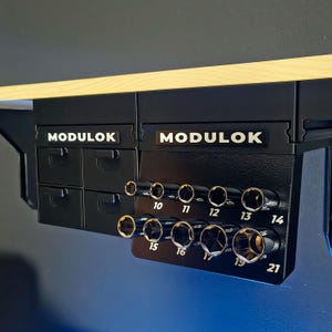 May include: Black Modulok tool organizer with drawers and socket holders. The sockets are labeled with sizes ranging from 10 to 21. The Modulok logo is displayed in white.