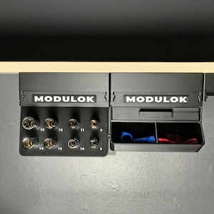 May include: Black Modulok tool organizer with sockets and a drawer containing blue and red tools. The sockets are labeled with numbers. The Modulok logo is displayed on the top of the organizer.