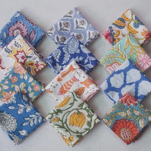 Puede incluir: Una colección de doce servilletas de tela cuadradas dispuestas en cuadrícula, cada una con distintos patrones estampados en bloque en azul, amarillo, rosa, verde y naranja, con motivos florales, de hojas y geométricos.