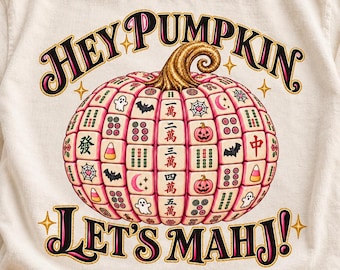 May include: A cream-colored t-shirt featuring a graphic of a pumpkin constructed from mahjong tiles. The text reads "HEY PUMPKIN" and "LET'S MAHJ!". The tiles display various symbols including ghosts, bats, pumpkins, and Chinese characters.