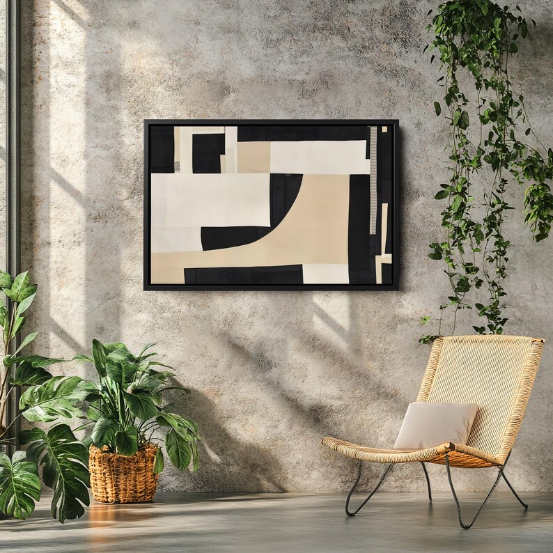 May include: A rectangular wall art piece featuring an abstract composition of black, cream, and beige geometric shapes enclosed in a thin black frame. The design consists of solid blocks and curved lines arranged in a balanced, non-representational layout.