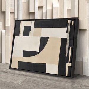 May include: A rectangular framed wall art piece featuring an abstract composition of geometric shapes in black, cream, and beige. The design consists of solid blocks and curved forms arranged in a layered, non-representational pattern within a black frame.