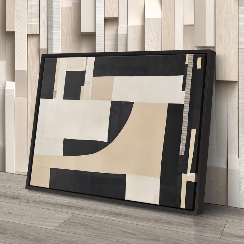 May include: A rectangular framed wall art piece featuring an abstract composition of geometric shapes in black, cream, and beige. The design consists of solid blocks and curved forms arranged in a layered, non-representational pattern within a black frame.