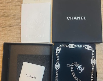Collar gargantilla CHANEL 21A con dijes CC de cristal, 100% auténtico, color plata.