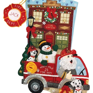 Pu&ograve; includere: Una calza di Natale con un camion dei pompieri rosso, un pupazzo di neve, cani dalmata e Babbo Natale. La calza presenta un design di caserma dei pompieri con il testo "Fire Dept." e "North Pole 25 Fire Dept."