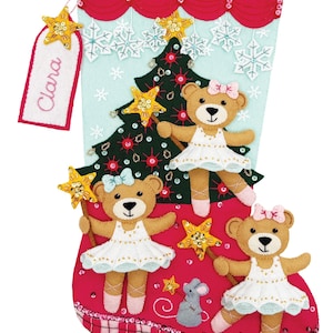 Puede incluir: Un calcetín navideño de fieltro con un puño a cuadros rojos y blancos y un cuerpo rojo. Presenta un árbol de Navidad, copos de nieve y tres osos de peluche con tutús. Se adjunta una etiqueta con el nombre "Clara".