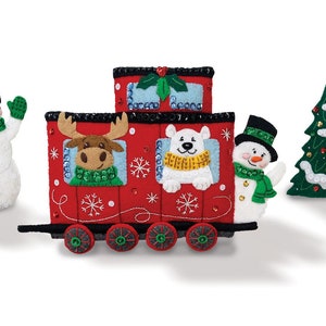 May include: A felt Christmas train with a moose, polar bear, and snowman peeking out of the windows. The train is red with black trim and has green wheels. There is a snowman with a broom and a green Christmas tree with white snowflakes.