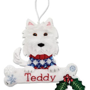 Può includere: Addobbo natalizio in feltro bianco con un cane che indossa un maglione rosso, blu e bianco. Il cane è seduto su un osso bianco con il nome "Teddy" ricamato su di esso. L'addobbo ha un anello per appenderlo ed è decorato con fiocchi di neve e agrifoglio.