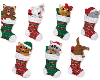 May include: Seven felt Christmas stockings with different coloured cats peeking out of the top. The stockings are red and green with white trim and sequins.