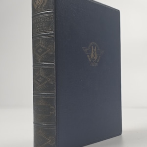 Pode incluir: Um livro de capa dura azul-escuro com um emblema dourado na capa frontal. A lombada apresenta letras douradas que dizem UNIVERSITEIT VOOR ZELFSTUDIE e padrões geométricos. O livro está na vertical, mostrando a capa frontal e a lombada.