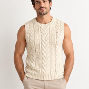 Könnte beinhalten: Eine ärmellose, cremefarbene Strickweste mit einem markanten vertikalen Zopfmuster, einem gerippten Rundhalsausschnitt und einem gerippten Saum. Das Kleidungsstück ist in einem dicken, strukturierten Strickdesign gefertigt, das über das Vorderteil verläuft.