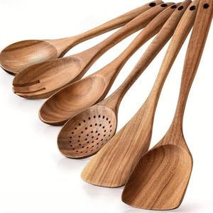 Puede incluir: Un juego de seis utensilios de cocina de madera, que incluye cucharas, cucharas ranuradas y esp&aacute;tulas. Los utensilios est&aacute;n hechos de madera de color marr&oacute;n claro y tienen un acabado liso. Cada utensilio tiene un agujero en el mango para colgar.