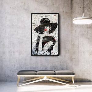 Pu&ograve; includere: Opera d'arte incorniciata raffigurante un ritratto composto da ritagli di giornale. La persona indossa un grande cappello nero e rossetto rosso. La parola "Style" &egrave; visibile. L'opera &egrave; sopra una panca.